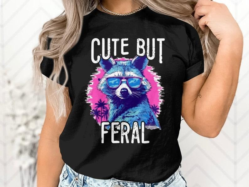 Cute But Feral T Shirt Hoodie Sweater, Quirky Raccoon Design, Trendsetters, Stylish Sunglasses, Casual Outings, Vibrant Pink, Summer Vibes, Humorous Gift