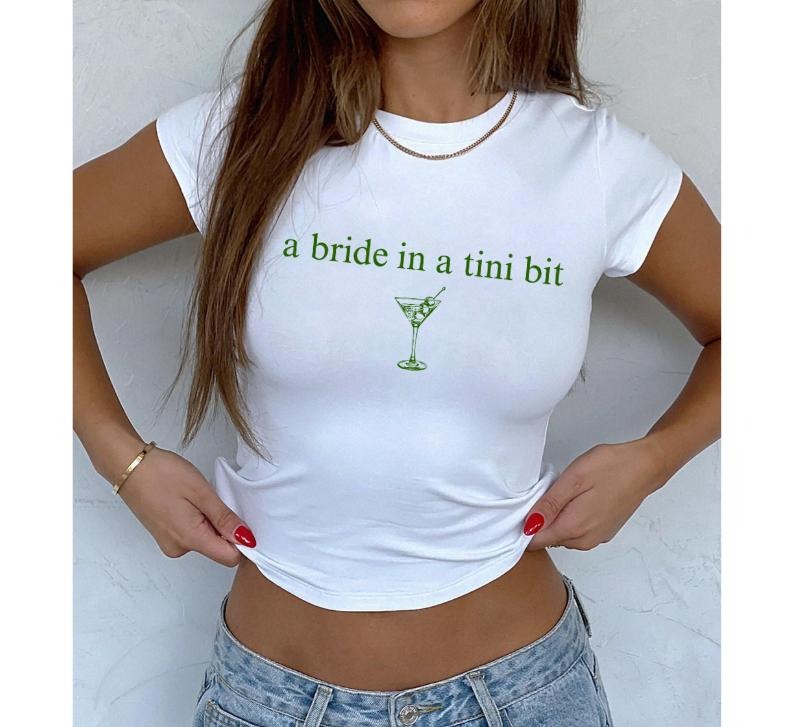 A Bride In A Tini Bit Baby Tee, Dirty Martini Themed Bachelorette Party Dirty Martini Bride Baby Tee, Dirty Martini Bachelorette Martini Bach Baby Tee