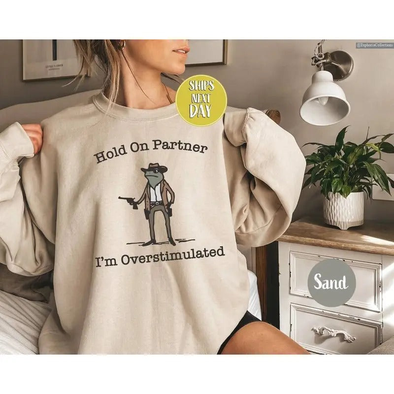 Hold On Partner I'm Overstimulated Western Cowboy Frog Funny Meme Sweater, Hoodie, Tee, Funny Vintage Meme Gifts for Friend , Global Trending Outfits
