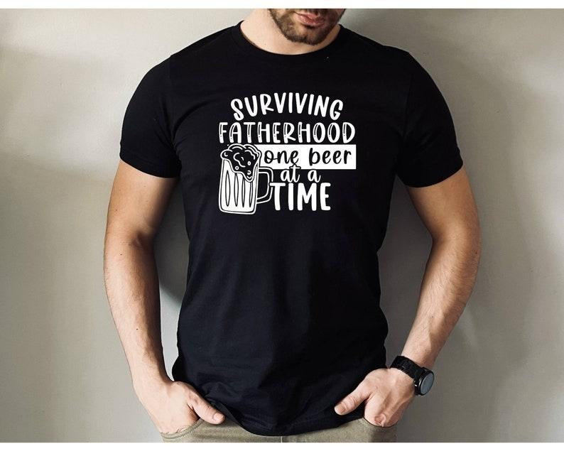 Surviving Fatherhood One Beer At A Time Shirt/T-shirt/Hoodie/Sweater, Fatherhood T-shirt, Father's Day Gift, Cool Dad Shirt, Funny Dad Shirt, Gift For Daddy Shirt